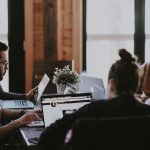 A team gathers around a desk in an office.