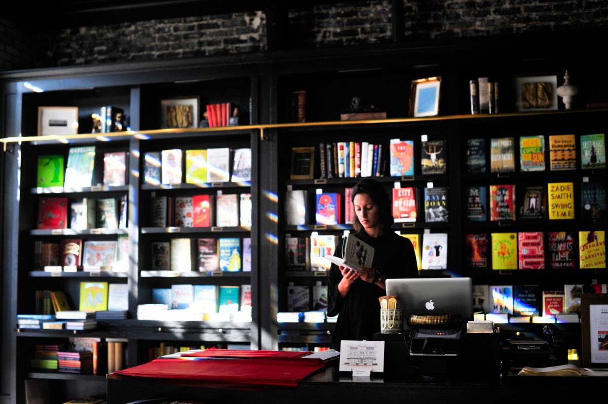 a clerk stands behind the register at a book store